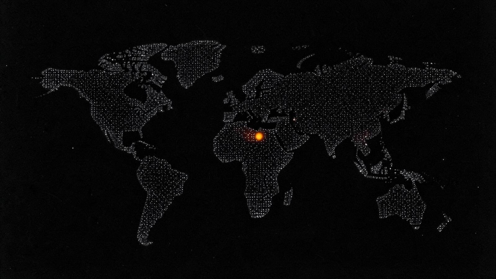 A dotted world map on black with a single lit point