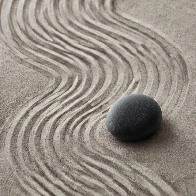 Gently raked sand beside a smooth stone
